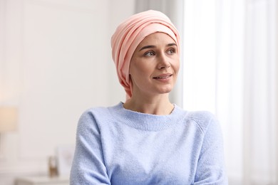 Photo of Portrait of smiling woman with cancer in headscarf indoors