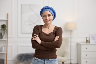 Photo of Portrait of young woman with cancer in headscarf indoors