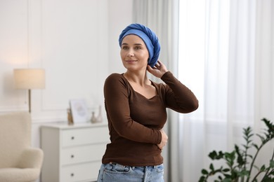 Photo of Young woman with cancer in headscarf indoors