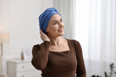 Photo of Smiling woman with cancer in headscarf indoors