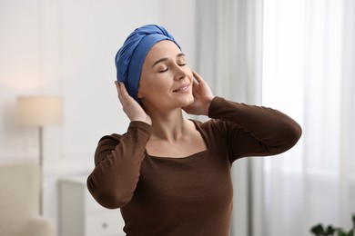 Photo of Smiling woman with cancer in headscarf indoors