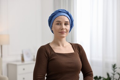 Photo of Portrait of young woman with cancer in headscarf indoors