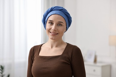 Photo of Portrait of smiling woman with cancer in headscarf indoors