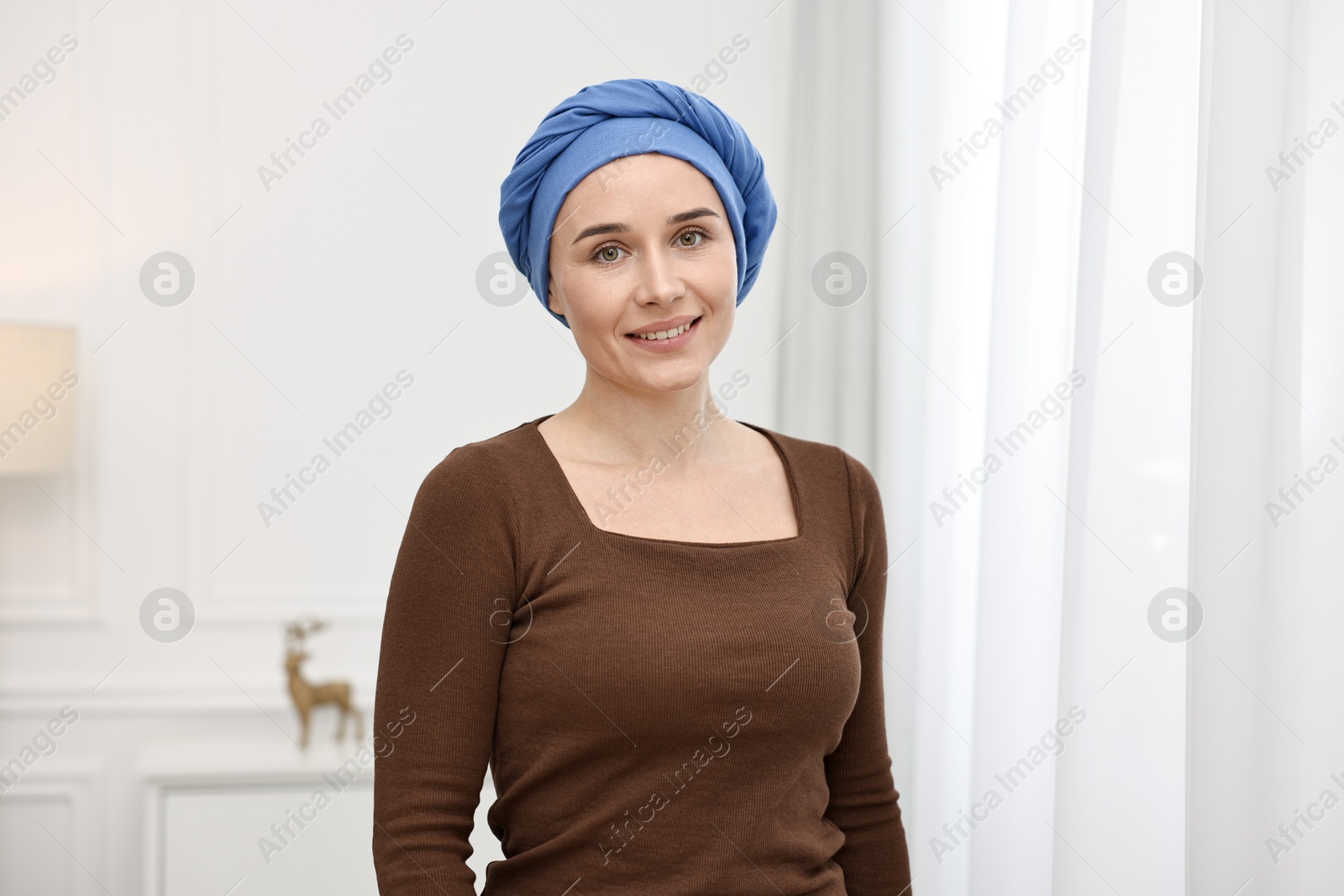 Photo of Portrait of smiling woman with cancer in headscarf indoors