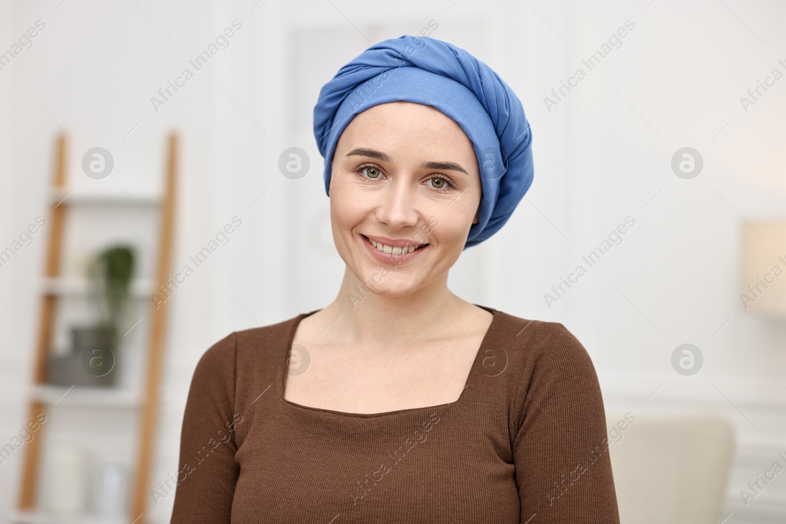 Photo of Portrait of smiling woman with cancer in headscarf indoors