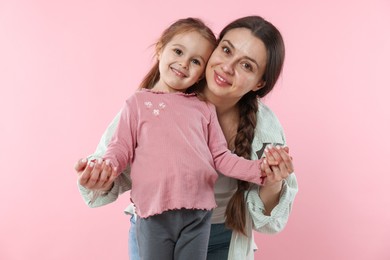 Photo of Family portrait of beautiful mother with little daughter on pink background