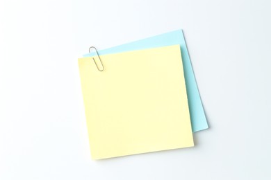 Paper notes with clip on light background, top view