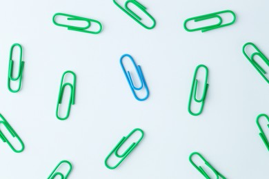 Many paper clips on light background, flat lay