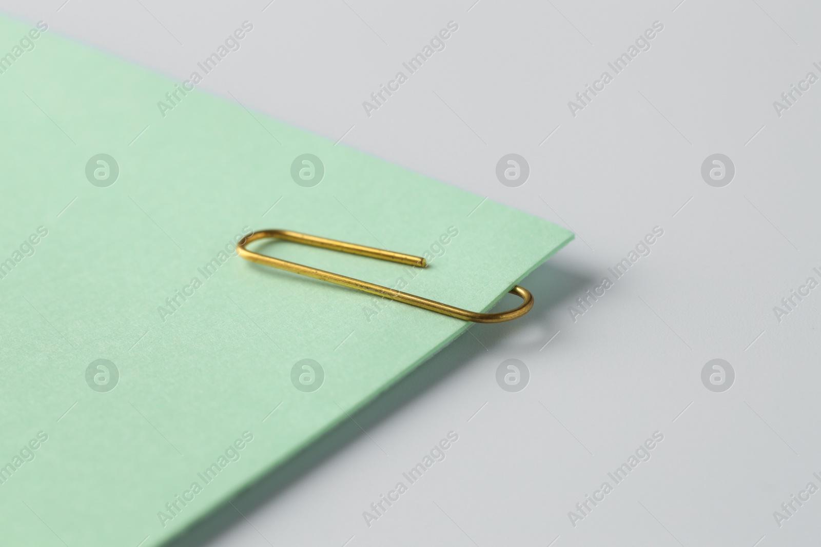 Photo of Paper note with clip on light background, closeup