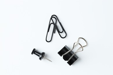 Paper clips and pin on white background, flat lay