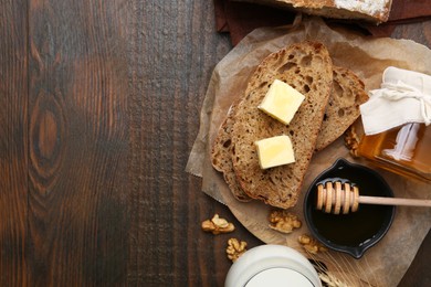 Photo of Slices of bread with butter, honey, milk and walnuts on wooden table, flat lay. Space for text