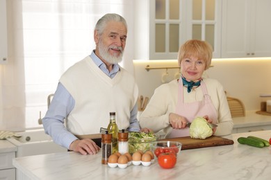 Photo of Senior couple cooking together at table in kitchen