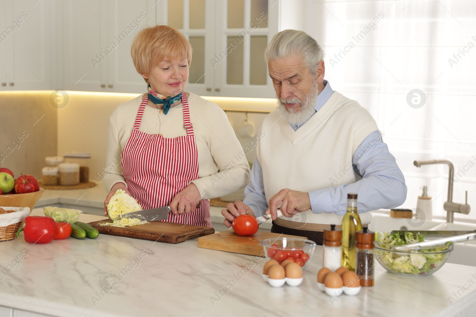 Photo of Senior couple cooking together at table in kitchen