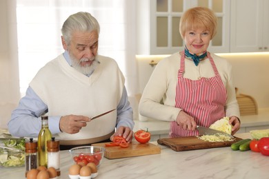 Photo of Senior couple cooking together at table in kitchen