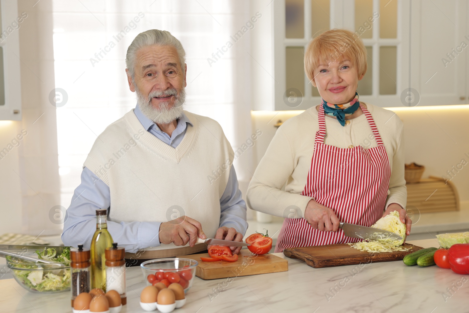 Photo of Senior couple cooking together at table in kitchen