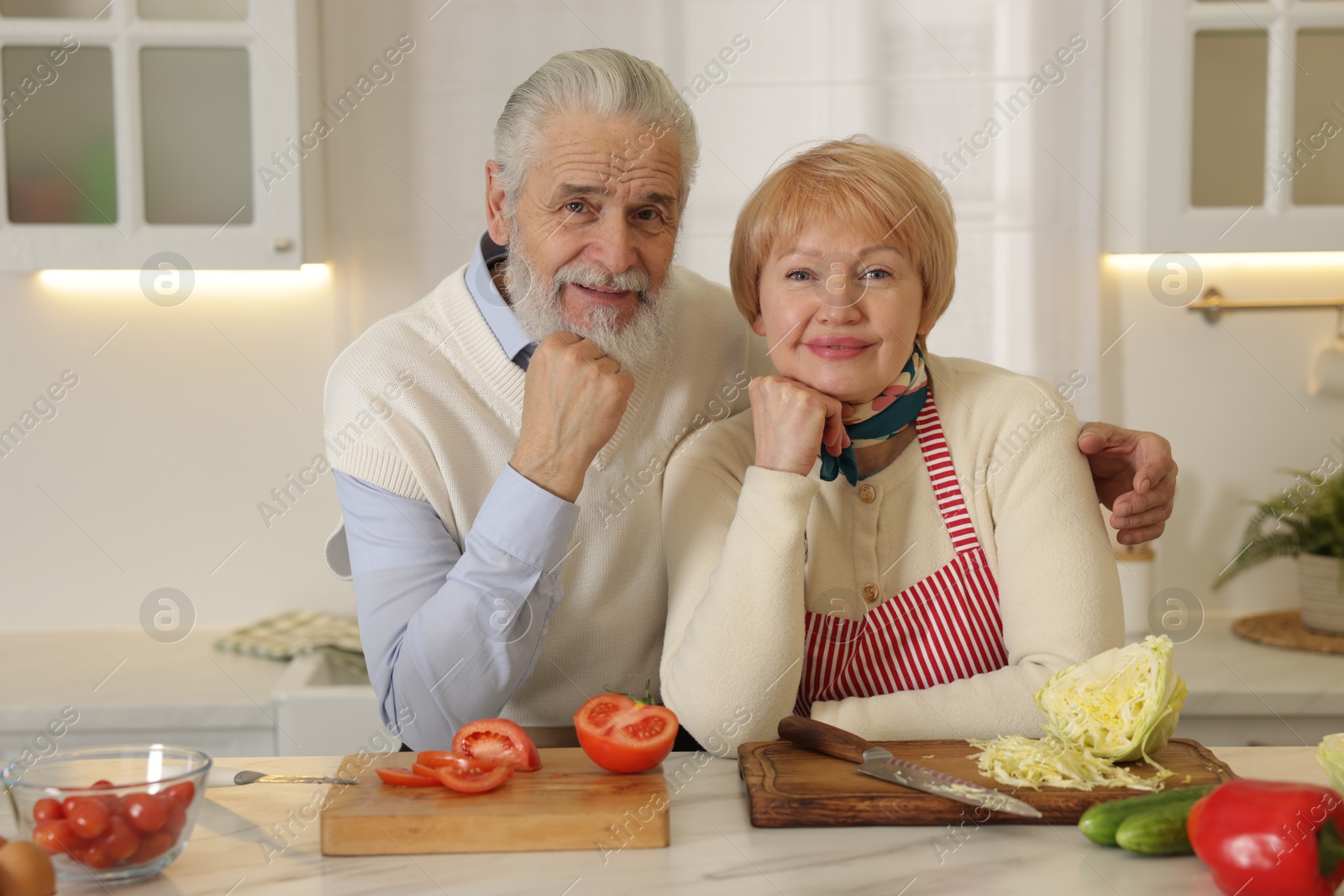 Photo of Senior couple cooking together at table in kitchen