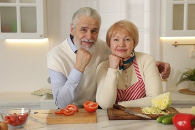 Photo of Senior couple cooking together at table in kitchen