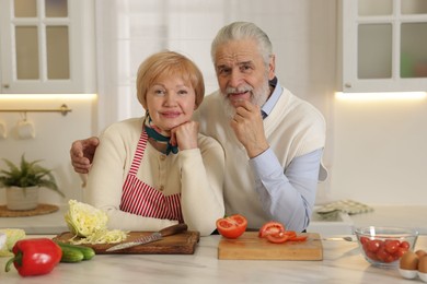 Photo of Senior couple cooking together at table in kitchen