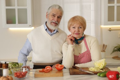 Photo of Senior couple cooking together at table in kitchen