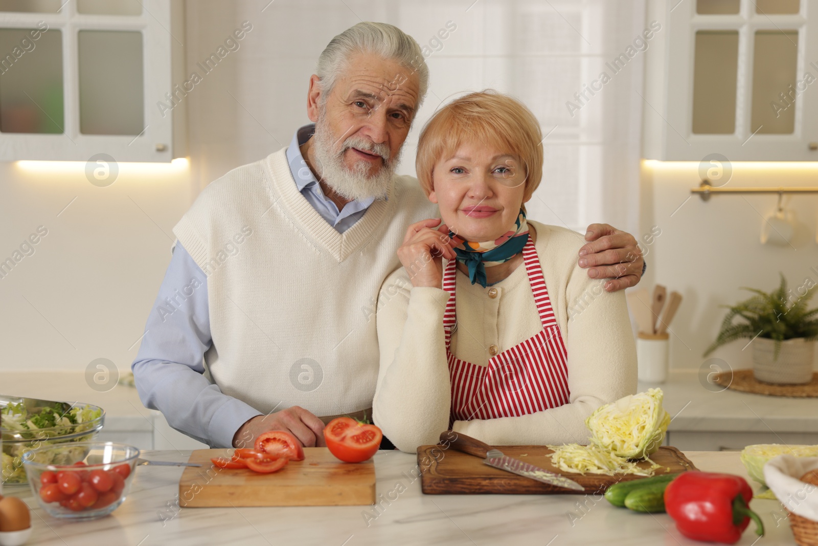 Photo of Senior couple cooking together at table in kitchen