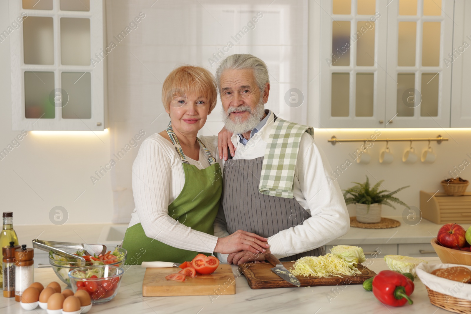 Photo of Senior couple cooking together at table in kitchen