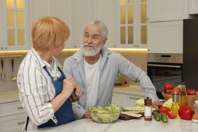 Photo of Senior couple cooking together at table in kitchen