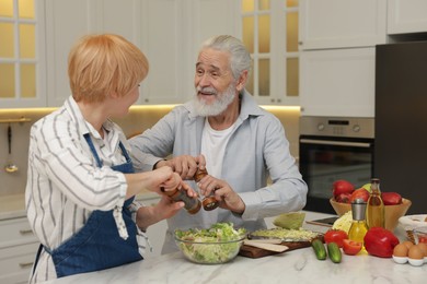 Photo of Senior couple cooking together at table in kitchen