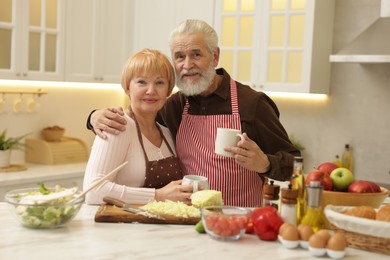 Photo of Senior couple having tea while cooking together in kitchen