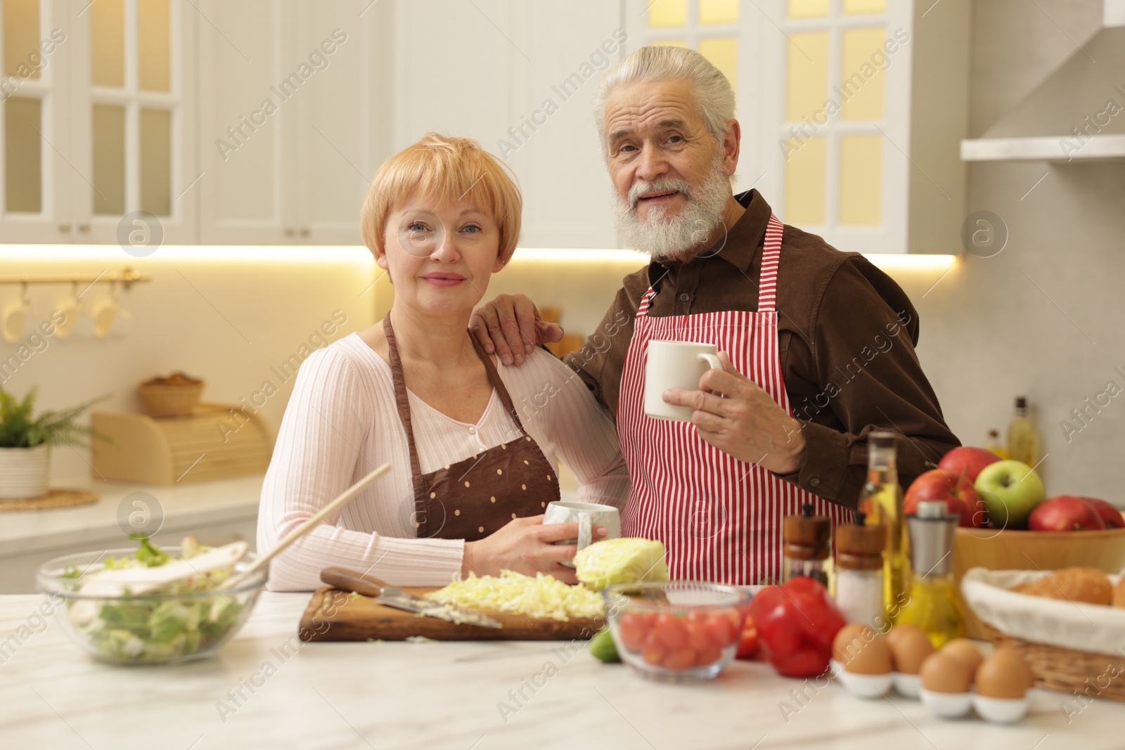 Photo of Senior couple having tea while cooking together in kitchen