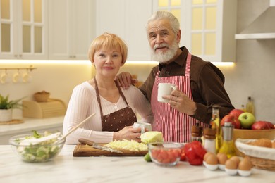 Senior couple having tea while cooking together in kitchen