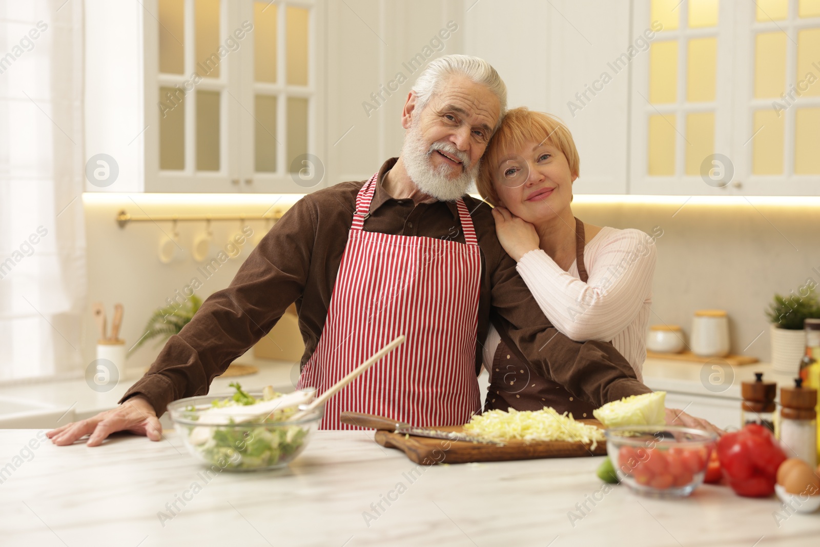 Photo of Senior couple cooking together at table in kitchen