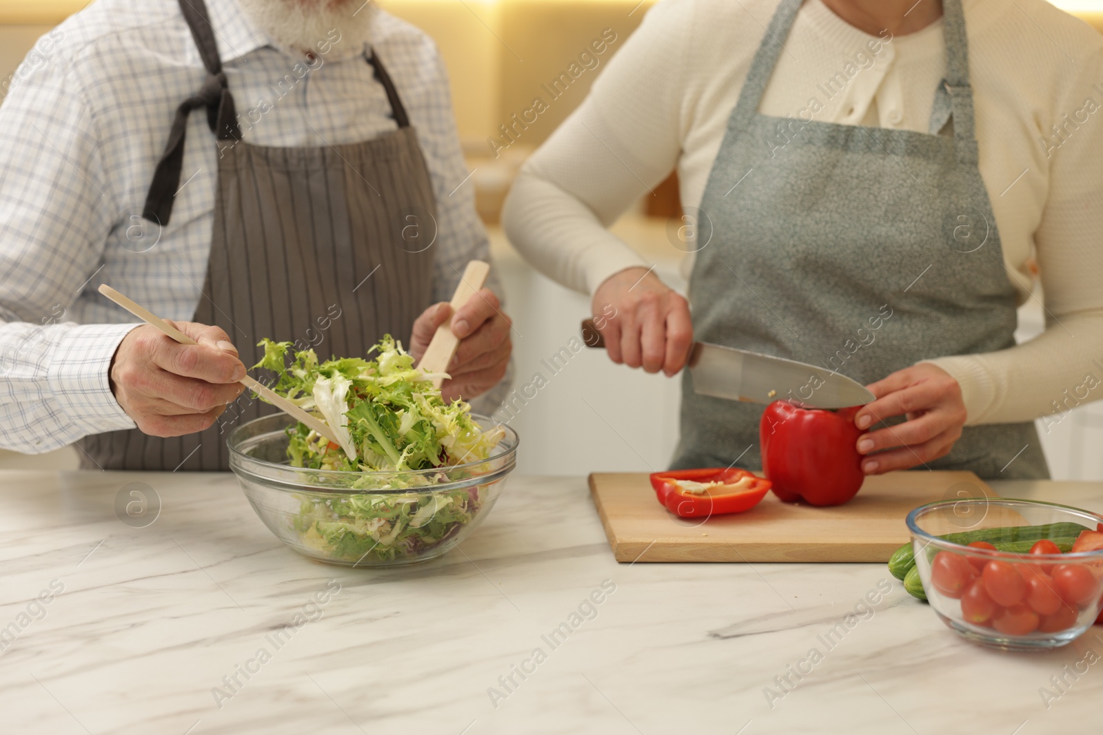 Photo of Senior couple cooking together at table in kitchen, closeup