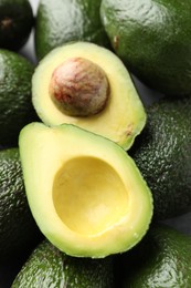 Photo of Many whole and cut avocados on table, above view