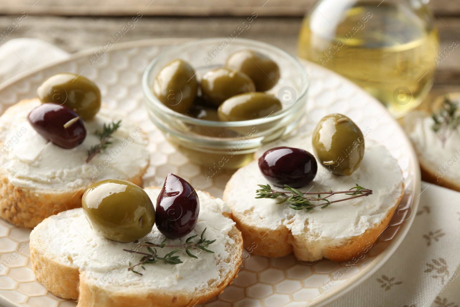 Photo of Delicious sandwiches with marinated olives, cream cheese and thyme on table, closeup