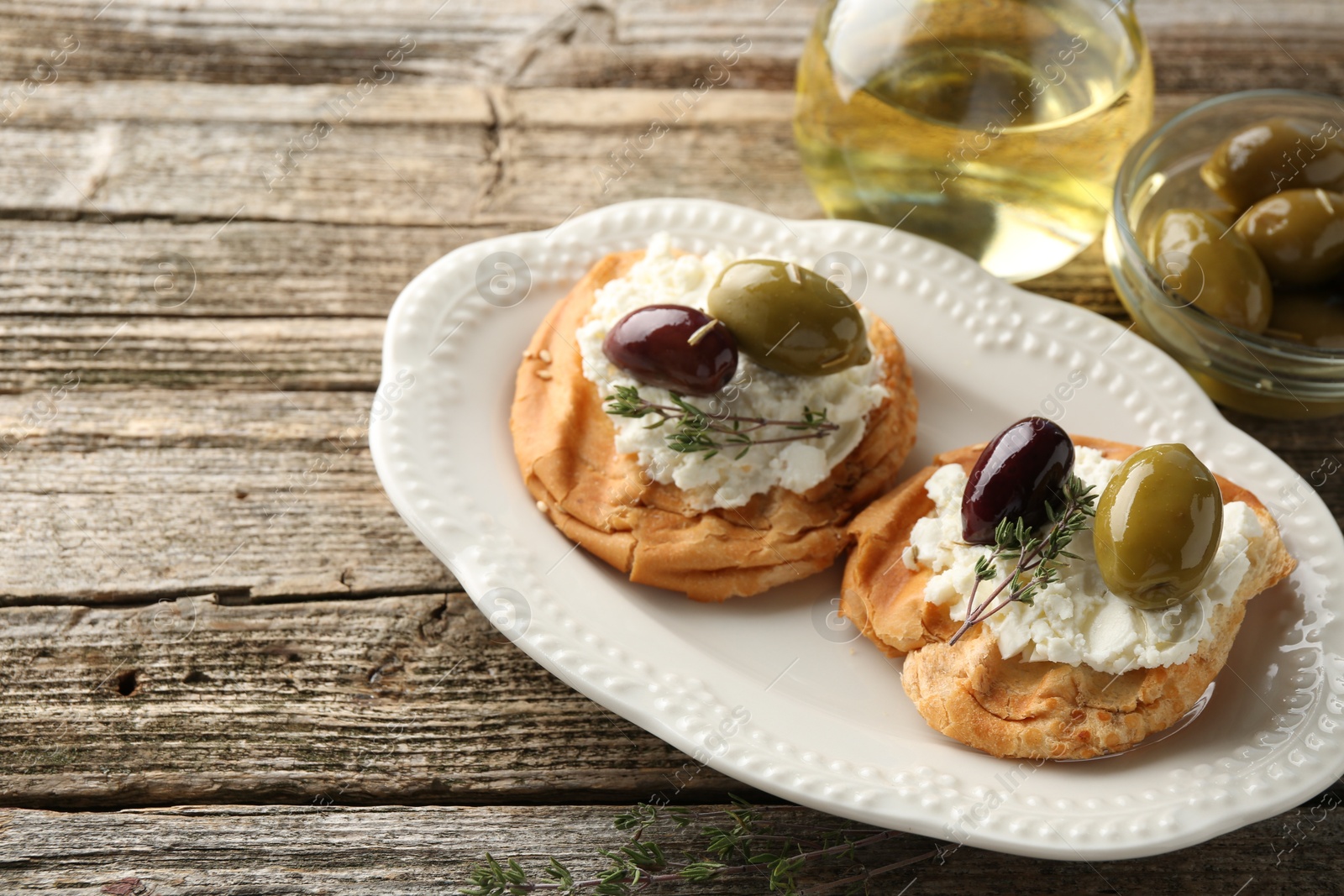 Photo of Delicious sandwiches with marinated olives, cream cheese and thyme on wooden table, closeup. Space for text