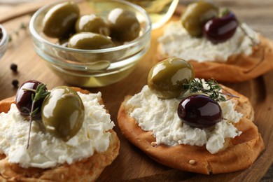 Photo of Delicious sandwiches with marinated olives, cream cheese and thyme on table, closeup