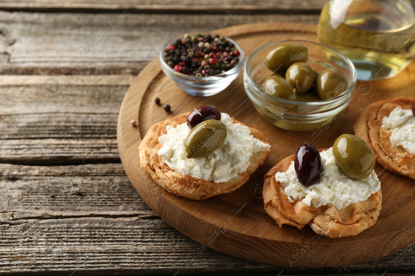 Photo of Delicious sandwiches with marinated olives, cream cheese and thyme on wooden table, closeup. Space for text