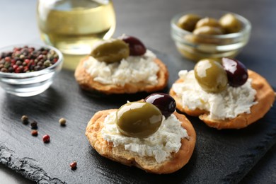 Photo of Delicious sandwiches with marinated olives, cream cheese and peppercorns on dark table, closeup