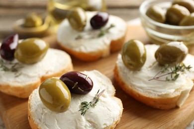 Photo of Delicious sandwiches with marinated olives, cream cheese and thyme on table, closeup