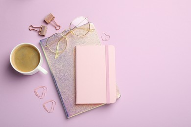 Paper clips, other different stationery, glasses and coffee on lilac background, flat lay. Space for text