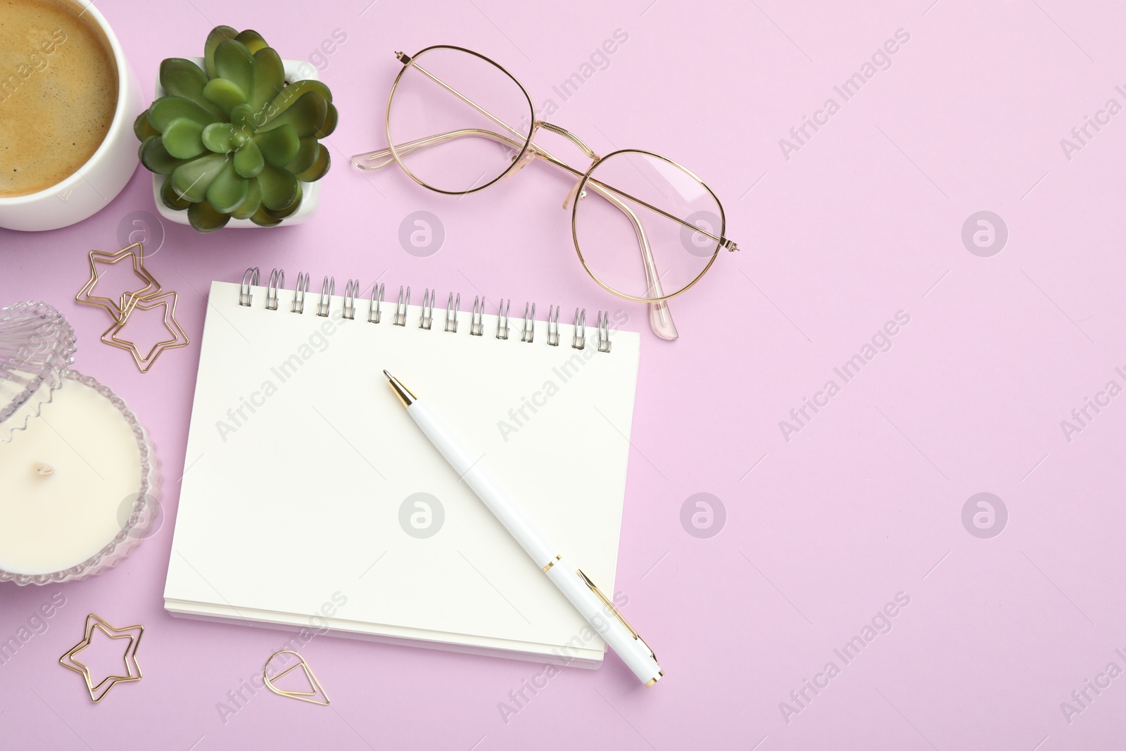 Photo of Paper clips, other different stationery, glasses, coffee and decor on lilac background, flat lay. Space for text