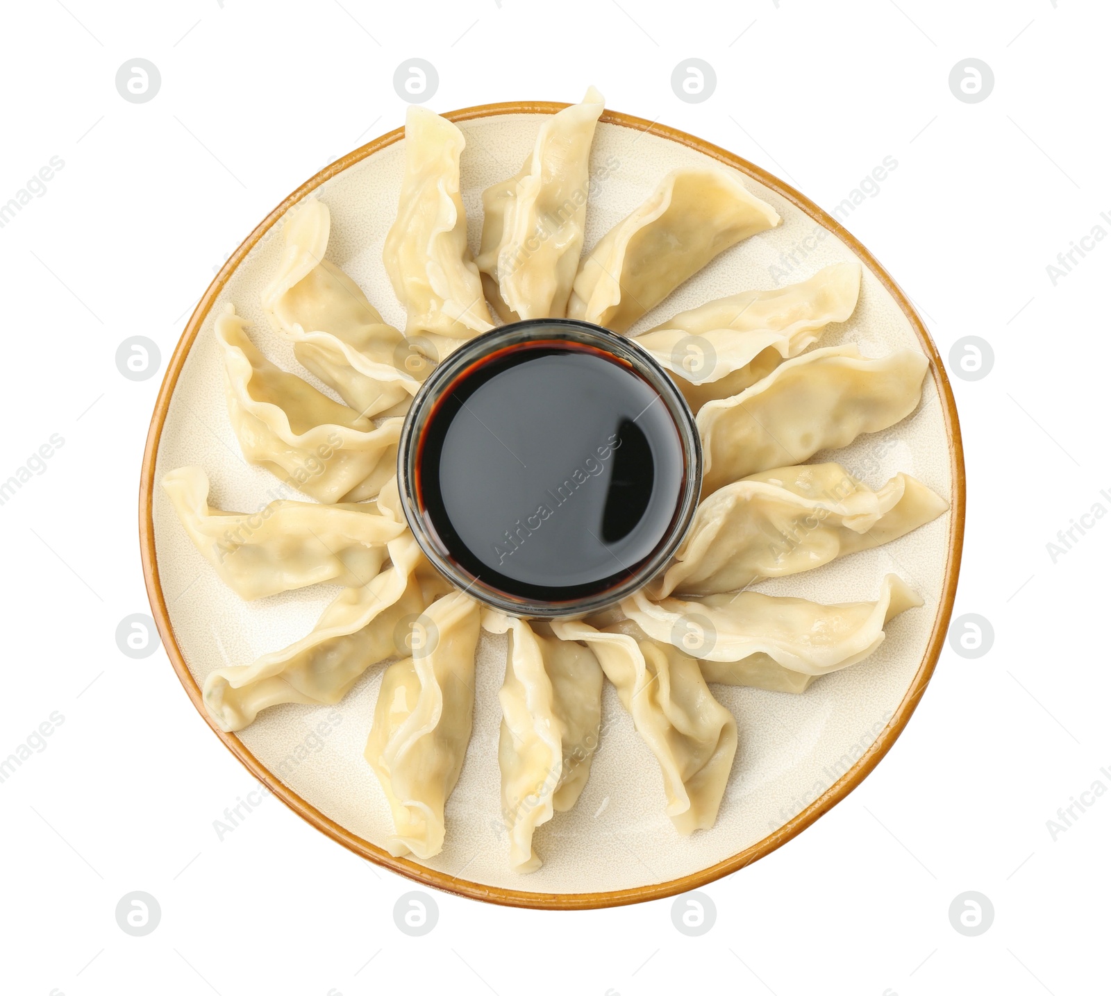 Photo of Tasty boiled gyoza (dumplings) with soy sauce on white background, top view