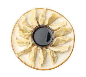 Photo of Tasty boiled gyoza (dumplings) with soy sauce on white background, top view