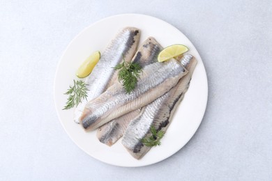 Marinated herring fillets with lime and dill on grey table, top view