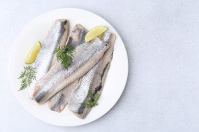 Photo of Marinated herring fillets with lime and dill on grey table, top view. Space for text