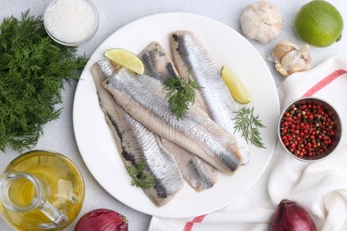 Marinated herring fillets with lime, dill and other products on grey table, flat lay