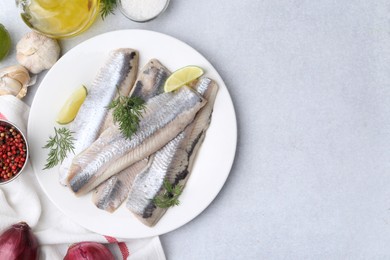 Marinated herring fillets with lime, dill and other products on grey table, flat lay. Space for text