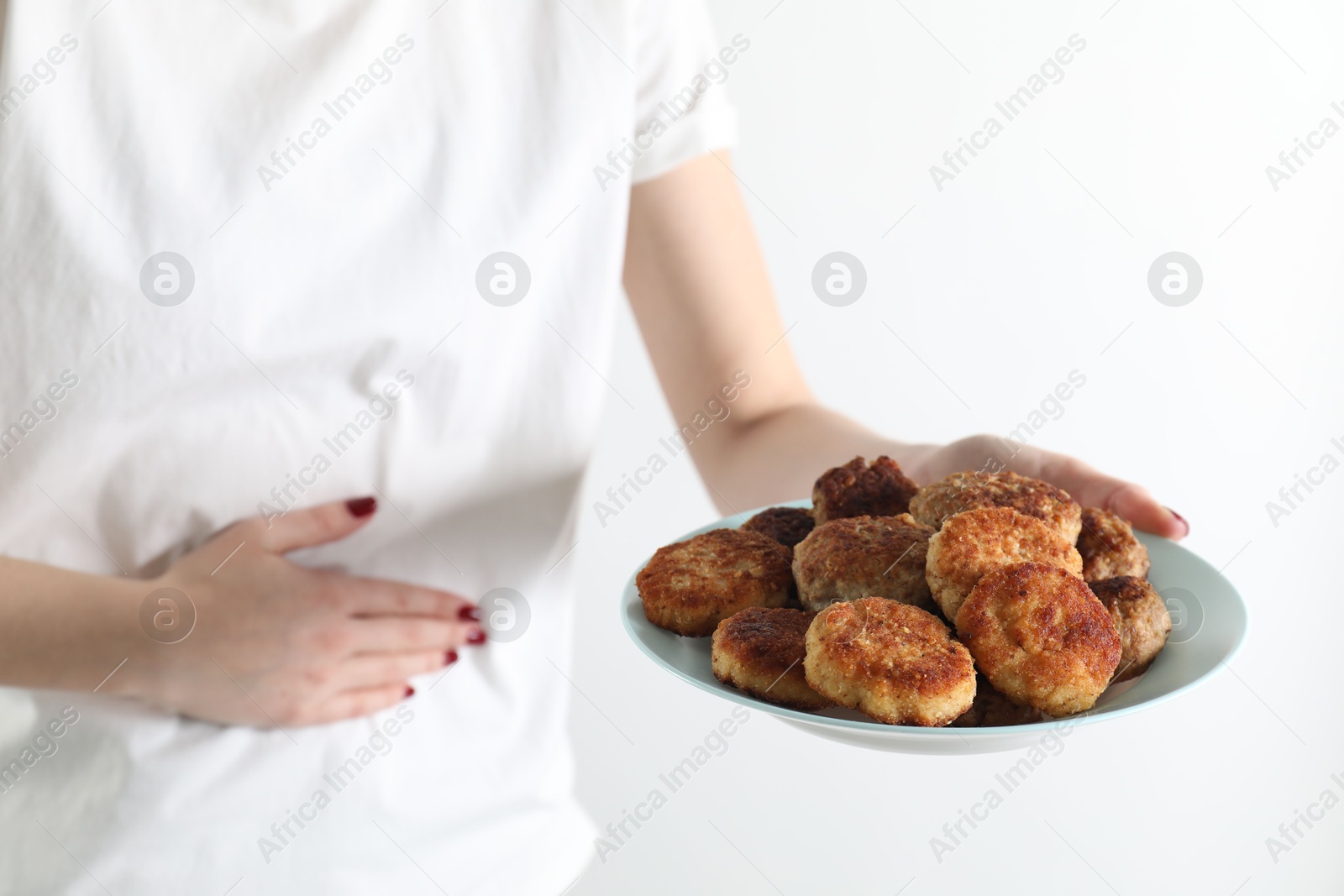 Photo of Woman with patties suffering from abdominal pain on white background, closeup. Food allergy concept