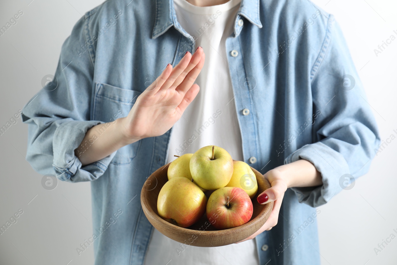 Photo of Woman refusing to eat apples on white background, closeup. Food allergy concept