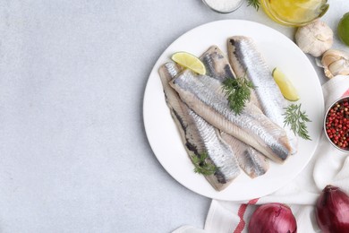 Marinated herring fillets with lime, dill and other products on grey table, flat lay. Space for text